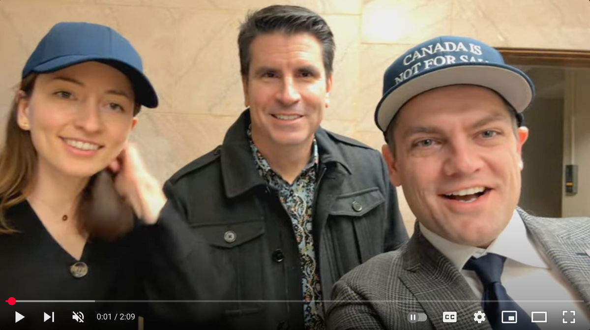Three people in a production update video, with two wearing Canada is Not For Sale hats